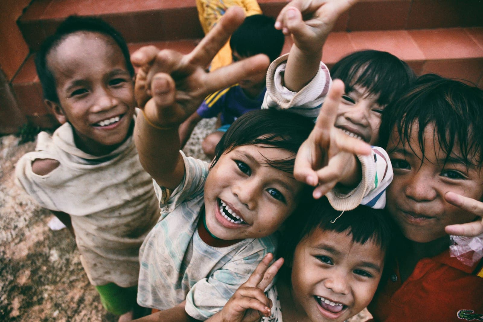 Grupo de niños sonriendo y saludando a la cámara en un día de verano